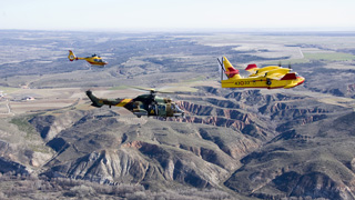 Un hidroavión "Canadair" y los helicóteros EC-135 y "Cougar" vuelan en formación por los alrededores de Madrid.